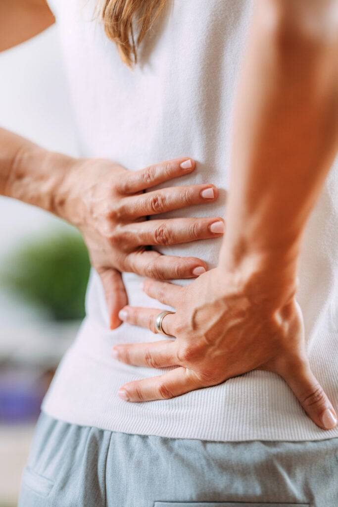 Signs Your Mattress Is Causing Your Back Pains - person holding their back